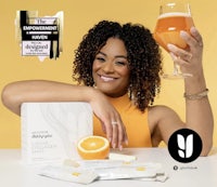 a woman holding a glass of orange juice